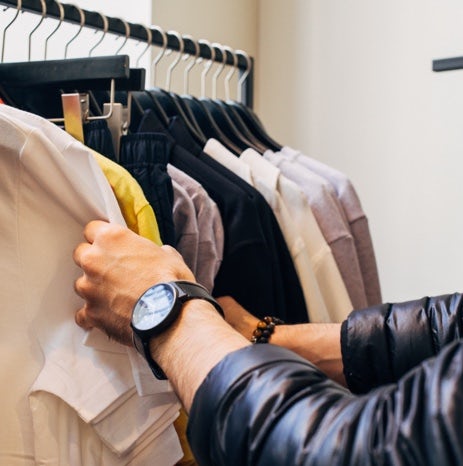 Person looking through clothes hanging in a closet