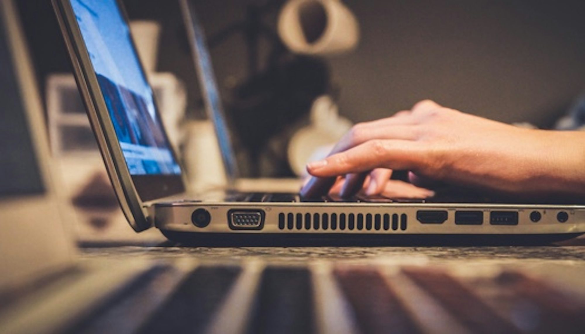 Side view of a someone typing on a laptop's keyboard