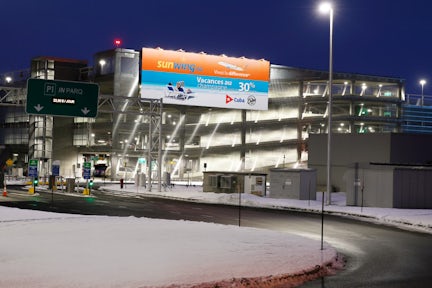 Large format Astral board outside of Quebec's Jean-Lesage airport featuring a SunWing ad
