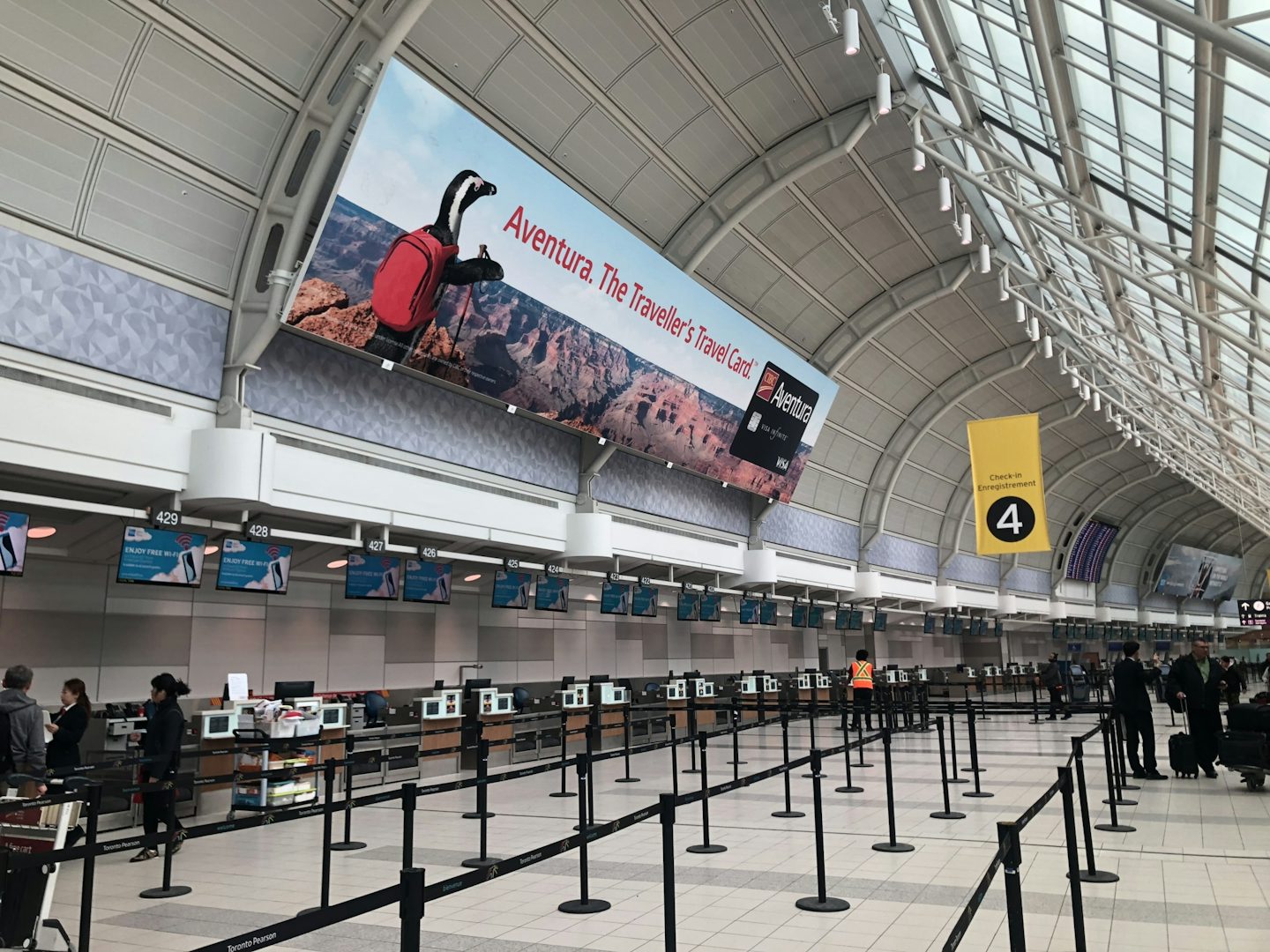 Large format Astral board featuring a CIBC ad atop check-in at Toronto's Pearson airport