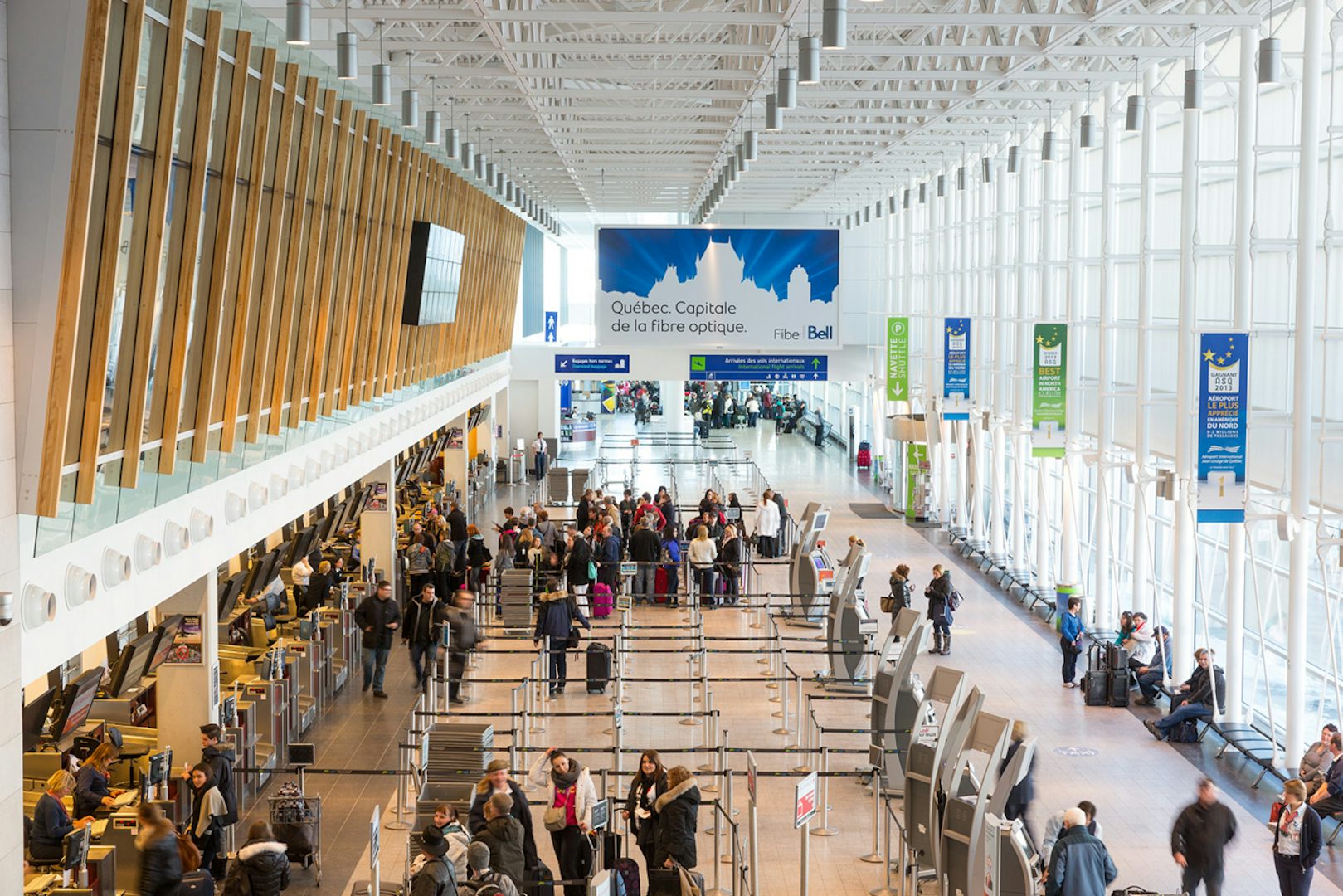 Large Astral banner atop check-in at Quebec's Jean-Lesage airport featuring a Bell Fibre ad