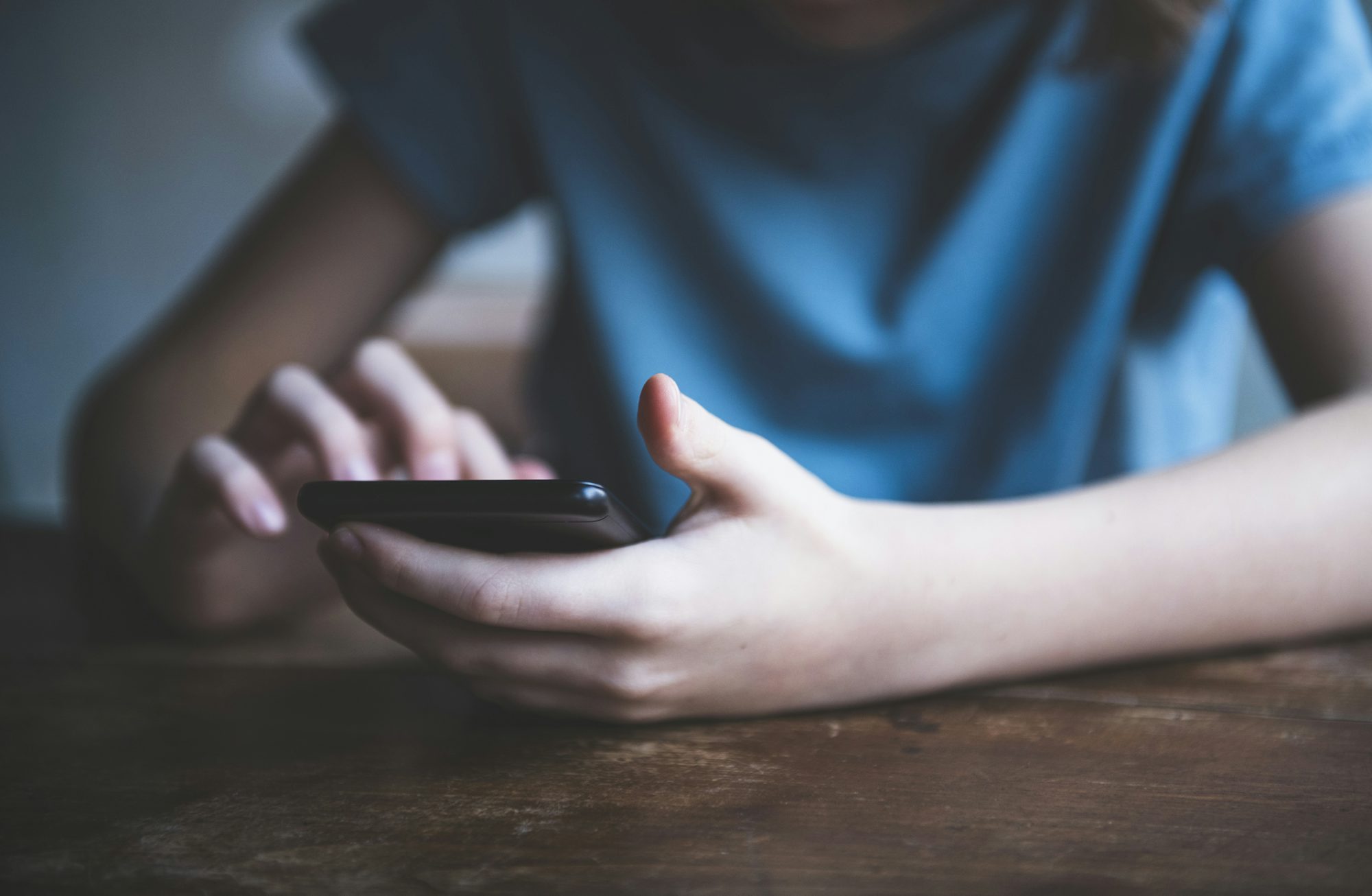Gros plan des mains d'une personne faisant défiler un smartphone