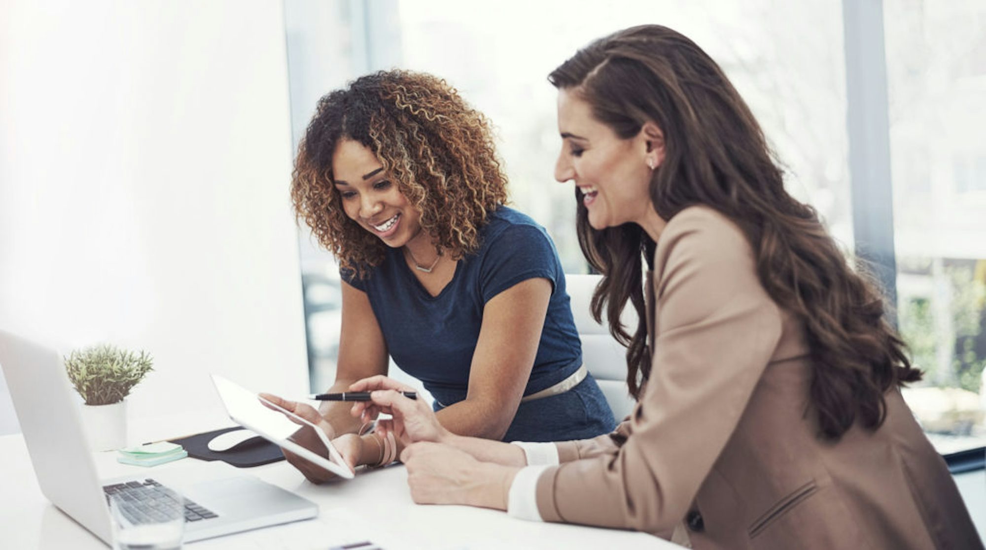 Shot of two businesswomen using a digital tablet together during a collaboration at work
