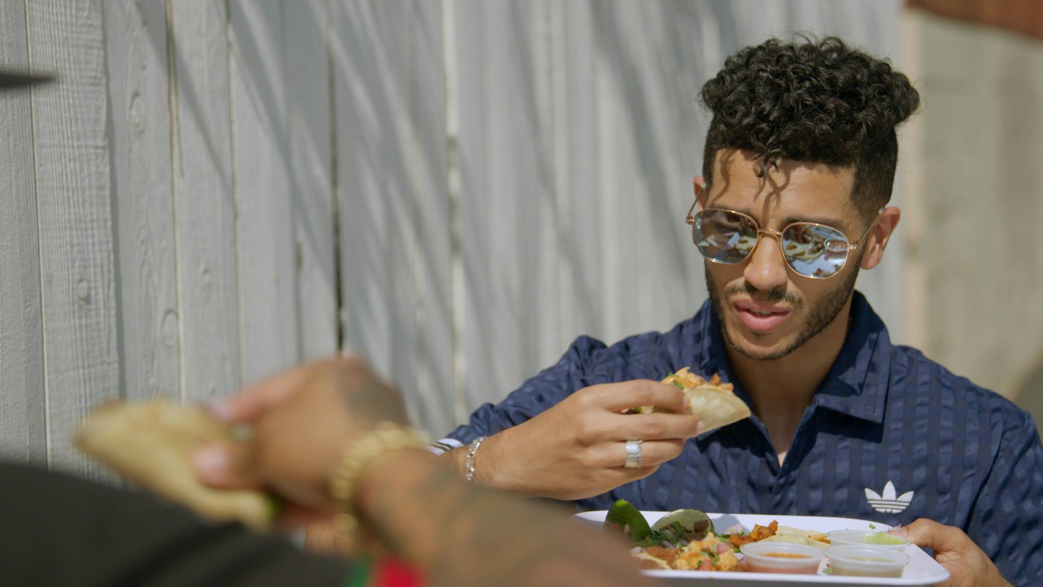 Mena Massoud eats a vegan taco in the series premiere of EVOLVING VEGAN