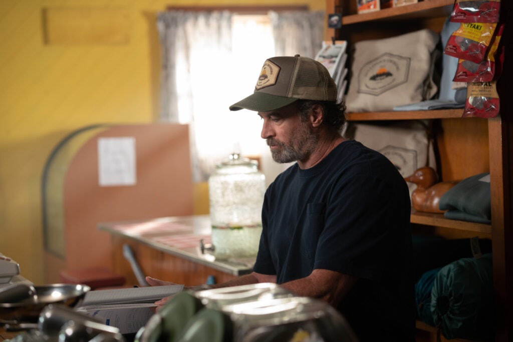 Scott Patterson as Sully sits and reads a letter in SULLIVAN'S CROSSING