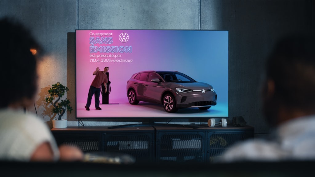 femme regarde la télévision avec une publicité d'auto