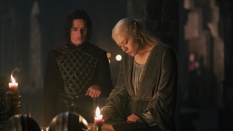Prince Jacaerys Velaryon and Queen Rhaenyra Targaryen speaking in front of candles and reading a history book about ancient valyria and Targaryen history