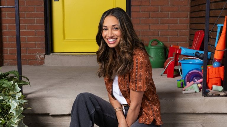Meaghan Rath as Astrid sitting in front of her house
