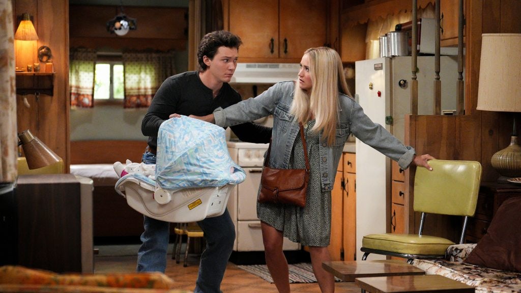 Georgie and Mandy in their house holding their baby