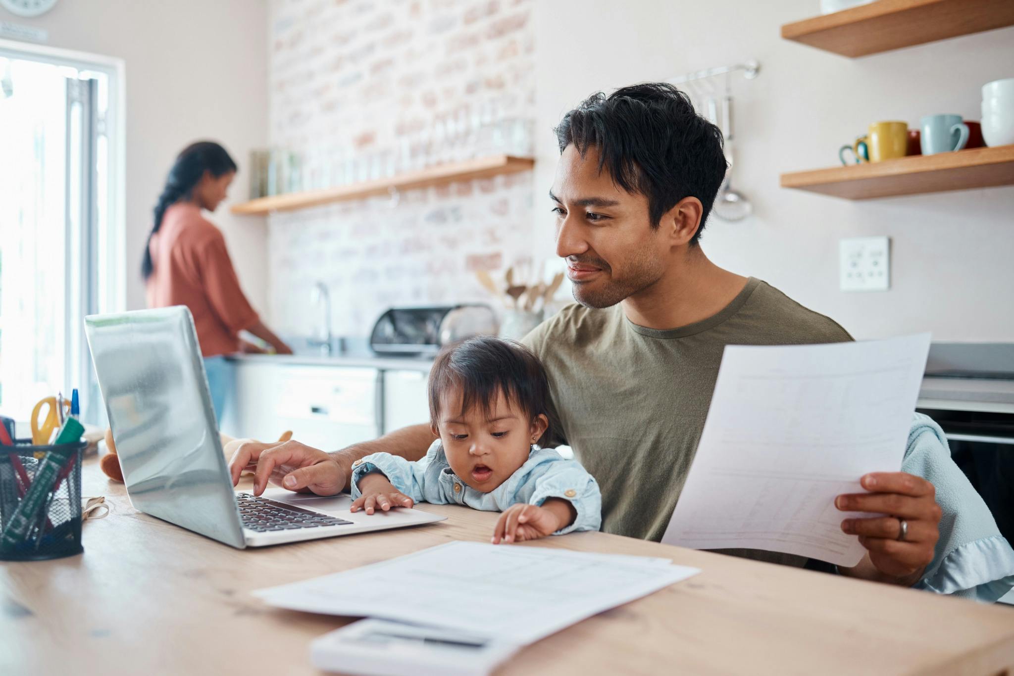 Family in the kitchen working on a laptop